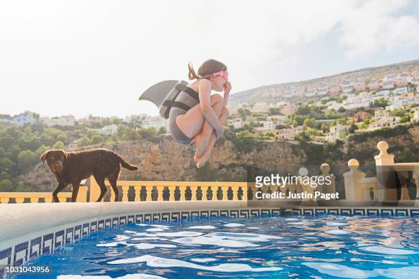 young girl jumping into pool - animal behavior fotografías e imágenes de stock