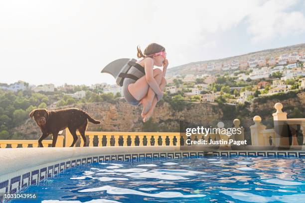 young girl jumping into pool - jump in pool stockfoto's en -beelden