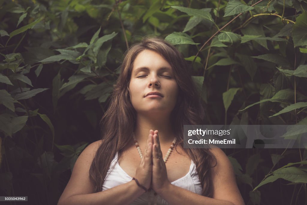 Young Mother To Be Practicing Prenatal Yoga Outdoors