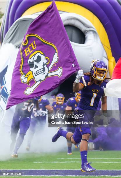 East Carolina Pirates wide receiver Deondre Farrier carries the East Carolina flag before a game between the North Carolina Tar Heels and the East...