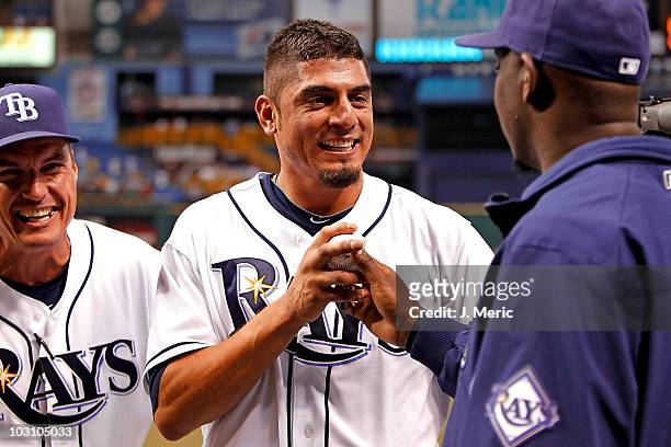 Pitcher Matt Garza of the Tampa Bay Rays gets a game ball from pitcher Rafael Soriano as pitching coach Jim Hickey looks on after the no hitter...