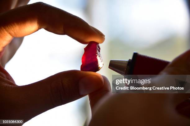 a worker examines a large ruby - ruby stockfoto's en -beelden