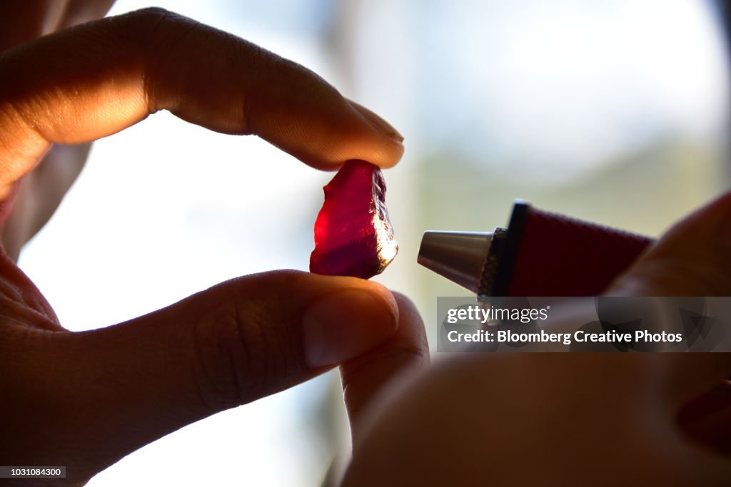 A worker examines a large ruby
