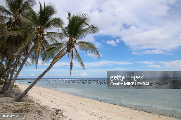 This photograph taken on September 2, 2018 shows a beach view in Ewa on the Pacific island of Nauru. - A cluster of corrugated iron huts resembling...