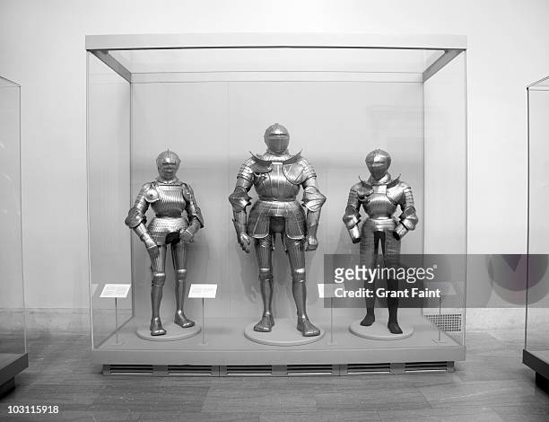 display case of  various sizes of armoured suits - vitrinekast stockfoto's en -beelden