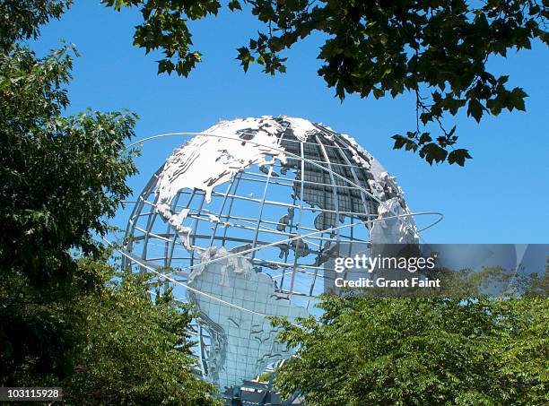 massive earth globe in treed area. - flushing queens stock-fotos und bilder