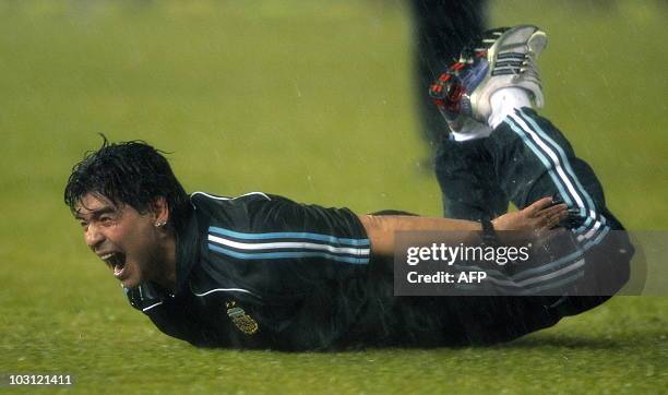 Argentina's national team coach Diego Maradona celebrates under a heavy rain, after footballer Martin Palermo scored the team's second goal against...