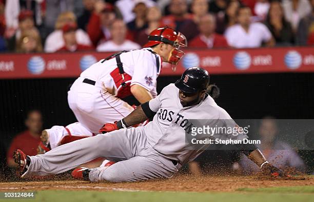 David Ortiz of the Boston Red Sox slides past catcher Jeff Mathis of the Los Angeles Angels of Anaheim as he scores from first on a double by Adrian...