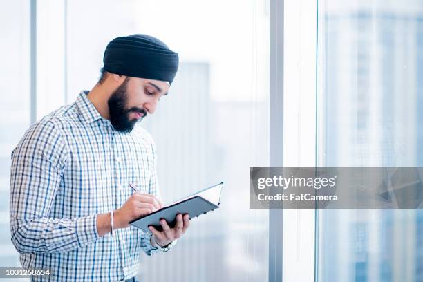 schrijven in notebook - sikhisme stockfoto's en -beelden