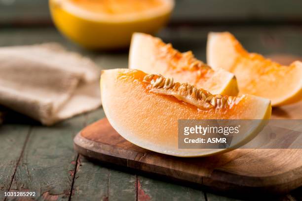 rebanada de melón maduro en una tabla de cortar - melón de castilla fotografías e imágenes de stock