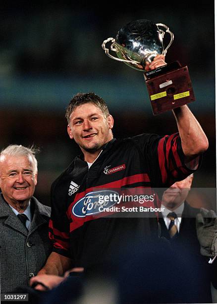 Todd Blackbadder of the Canterbury Crusaders holds the trophy aloft after their win over the ACT Brumbies 20-19 in the Final of the Super 12 played...