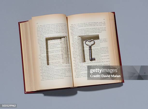 book with key in cut out compartment. - key findings stock pictures, royalty-free photos & images