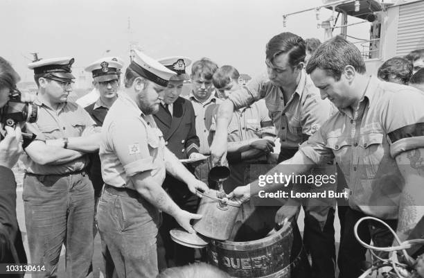 The end of a Royal Navy tradition, as the daily ration of rum is abolished due to safety concerns, 31st July 1970. LSA Michael Johns pours a final...