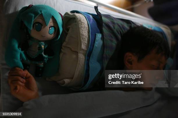 Akihiko Kondo sleeps with his favourite stuffed 'Hatsune Miku', something he has been doing for 9 years, at his house on September 11, 2018 in Tokyo,...