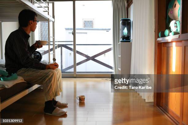 Akihiko Kondo stares at 'Hatsune Miku' while having breakfast at his house on September 11, 2018 in Tokyo, Japan. Akihiko Kondo, a 35 year-old school...