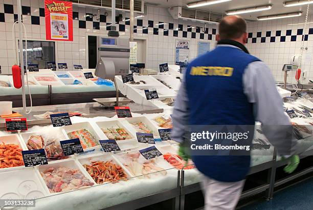 Metro AG employee passes the seafood counter in a Metro Cash & Carry store in Frankfurt, Germany, on Wednesday, July 28, 2010. Metro reports its...