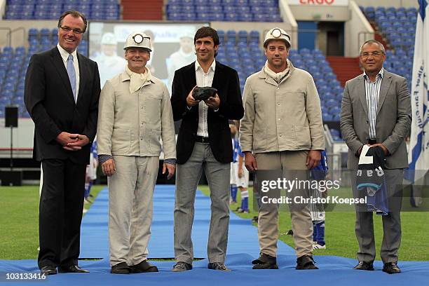 Raul Gonzalez gets a piece of coal as a present during the FC Schalke press conference at the Veltins Arena on July 28, 2010 in Gelsenkirchen,...