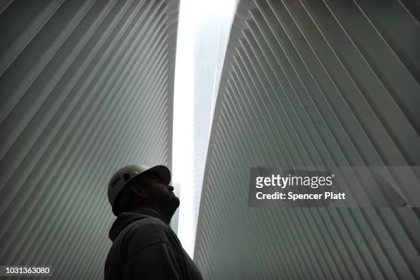 Construction worker stands in the World Trade Center Oculus as the retractable skylight is opened during a morning commemoration ceremony for the...
