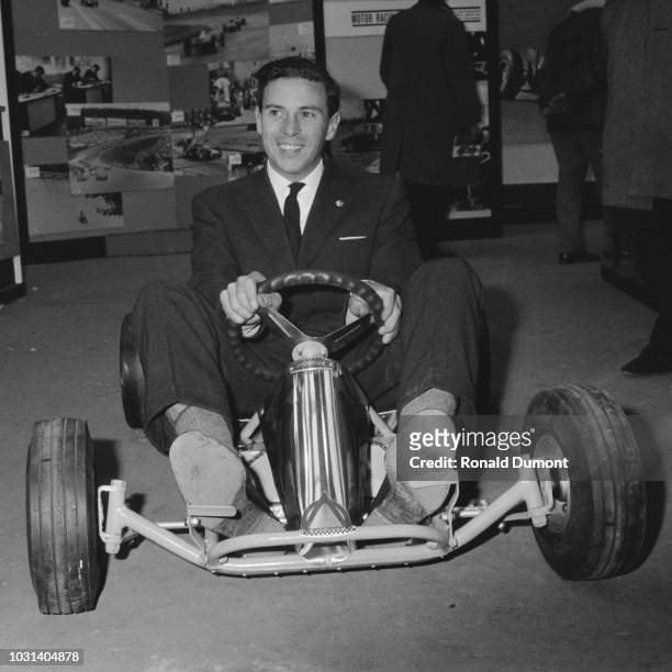 Scottish Formula One racing driver Jim Clark pictured sitting in the driver's seat of a go-kart at the Racing Car Show at Olympia in London on 26th...