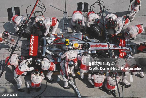 Lewis Hamilton of Great Britain driver of the Vodafone McLaren Mercedes McLaren MP4-22 Mercedes V8 is surrounded by mechanics as he makes a pit stop...