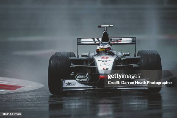 Mika Hakkinen of Finland drives the West McLaren Mercedes McLaren MP4/13 Mercedes V10 in the rain during practice for the Formula One Italian Grand...