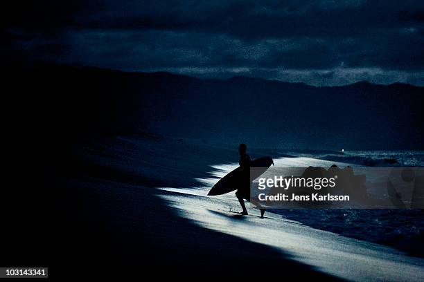 night surfer north shore - beach hold surfboard stock-fotos und bilder