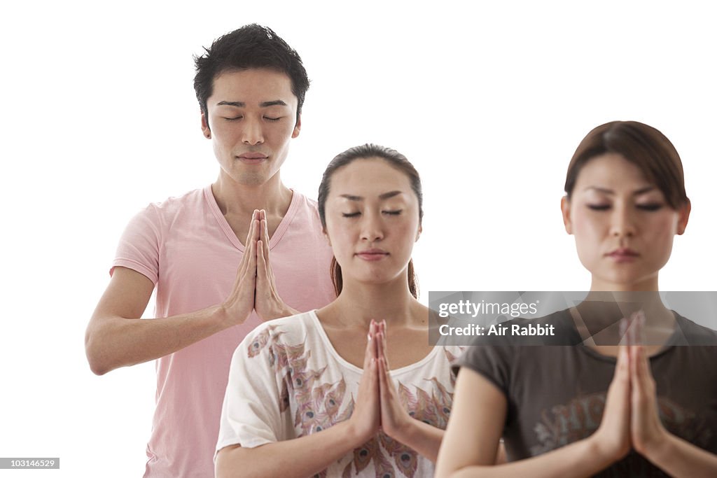 A Man and Two Women in Yoga Pose