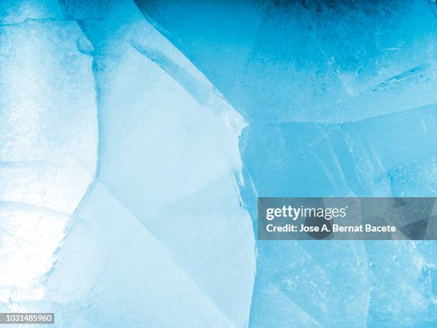 full frame of the textures formed of a block of cracked ice, on a light blue background. - ice texture foto e immagini stock