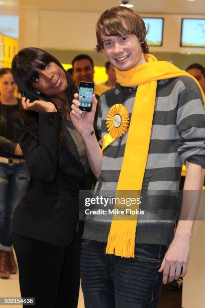 American R&B artist Kelly Rowland poses for a photo with the first customer Jack Breen at the release of the iPhone 4 for Optus on July 30, 2010 in...