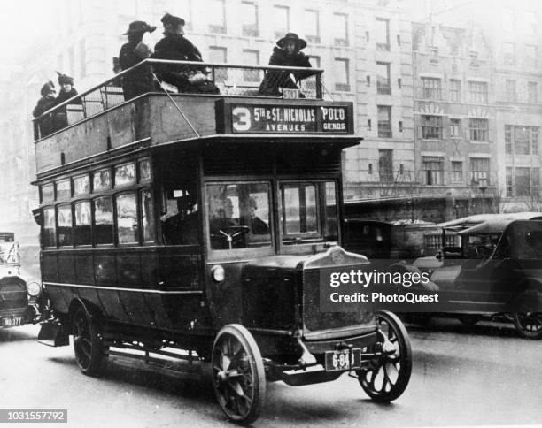 View of a double-decker bus with a number of passengers on the upper deck, New York, New York, 1915.