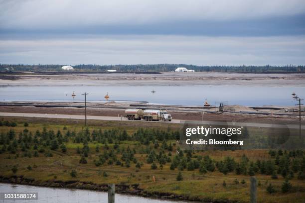 Truck drives past a tailings pond at the Syncrude Canada Ltd. Facility in the Athabasca oil sands near Fort McMurray, Alberta, Canada, on Sunday,...