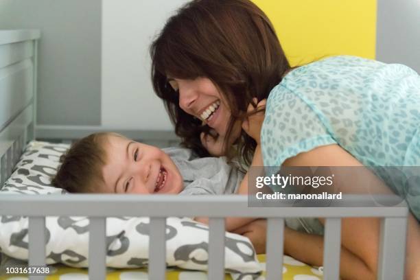 mom and her son with down syndrome after nap - developmental disability stock pictures, royalty-free photos & images