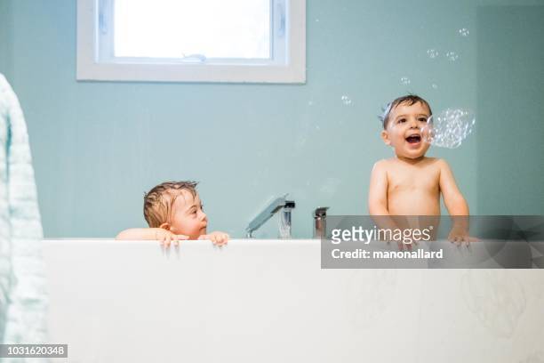 down's syndrome sweet boy in the bath with his brother - taking a bath stock pictures, royalty-free photos & images