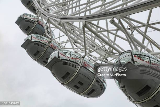 London Eye during a cloudy day in London, UK. The London Eye is one of the largest Ferris wheels in Europe. It is the most popular touristic...