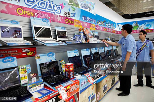 Samsung Electronics Co. Sales staff look at laptop computers at a store in Seoul, South Korea, on Friday, July 30 , 2010. Samsung Electronics Co.,...