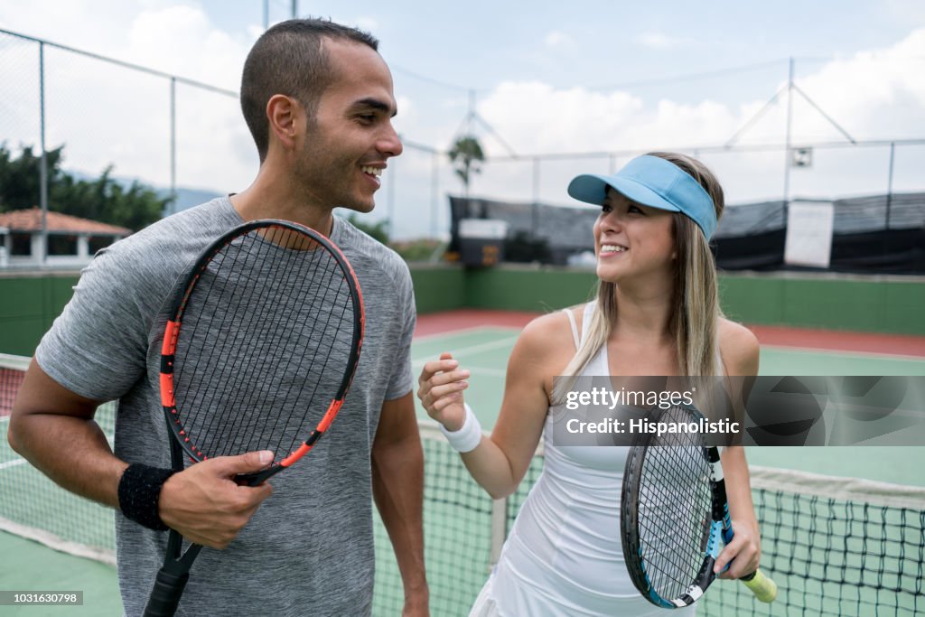 Volwassen paar tennisspelers praten na het beëindigen van het spel op zoek zeer tevreden