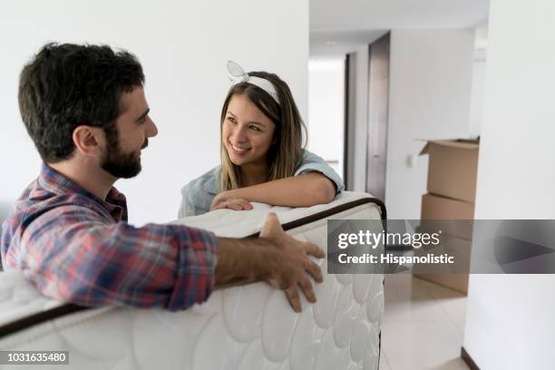 speelse vrouw met haar partner terwijl hij op een matras naar hun nieuwe plek - matras stockfoto's en -beelden