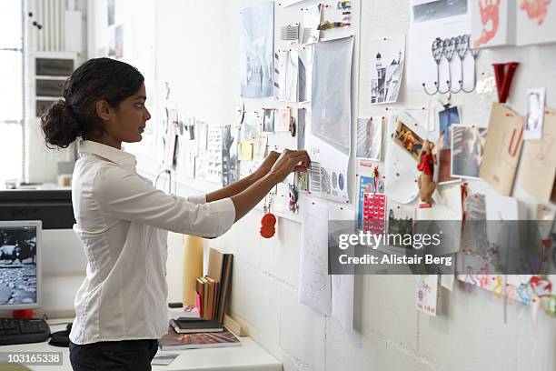 worker in office pinning picture on wall - pinning bildbanksfoton och bilder
