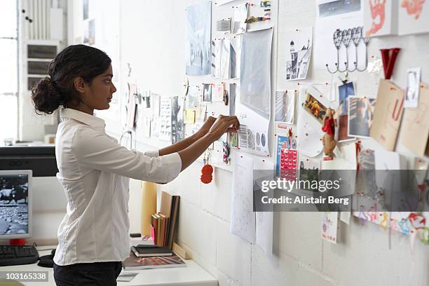 worker in office pinning picture on wall - bulletin board 個照片及圖片檔