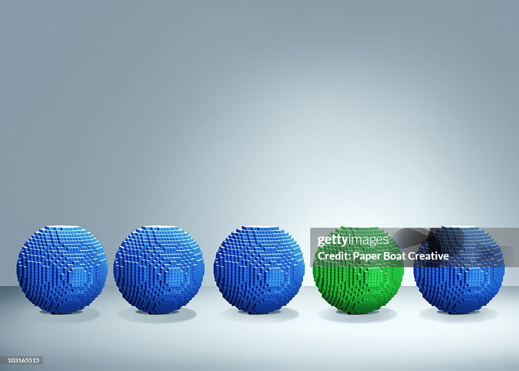 3D blue balls with one green one standing out