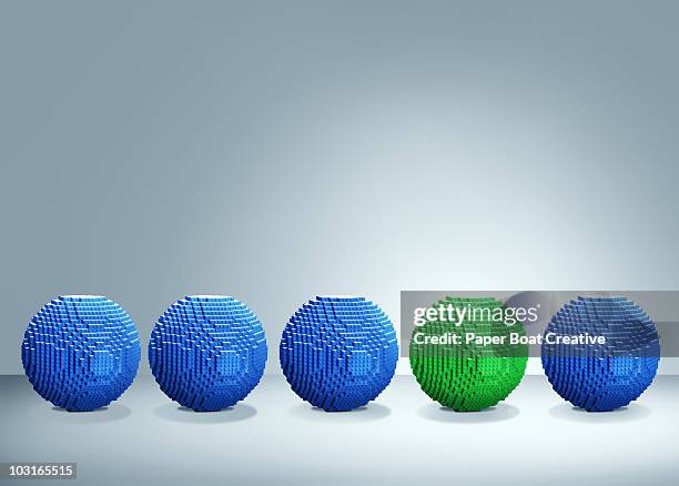 3d blue balls with one green one standing out - building blocks stock illustrations