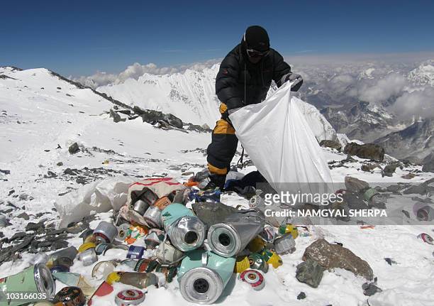 This picture taken on May 23, 2010 shows a Nepalese sherpa collecting garbage, left by climbers, at an altitude of 8,000 metres during the Everest...
