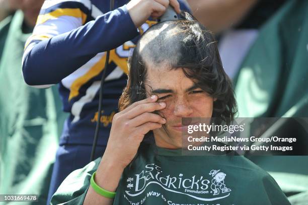 Adam Channeo Skogen grimaces as his classmate, Kayleigh Scott shaves his head during the Cubberly Elementary School's St. Baldrick's event Friday,...