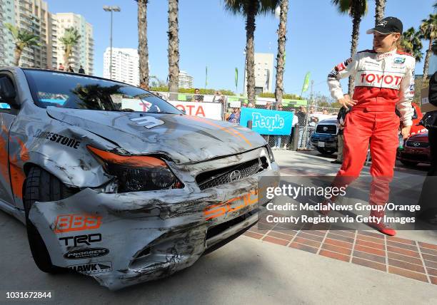 Megyn Price examines the damage to her car after she crashed in turn one of qualifying for the Pro/Celebrity race during the Toyota Grand Prix of...