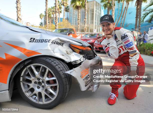 Megyn Price poses with the damage to her car after she crashed in turn one of qualifying for the Pro/Celebrity race during the Toyota Grand Prix of...