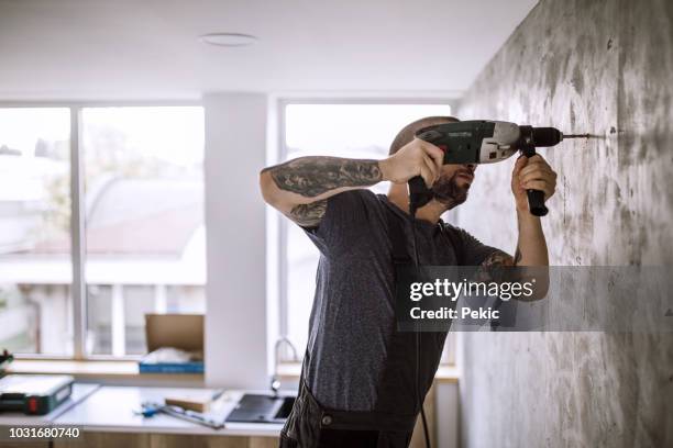 construction worker drilling hole in wall - man drill stock pictures, royalty-free photos & images