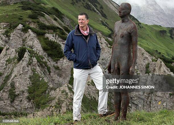 British artist Antony Gormley poses next to a life size bronze figure near the Kriegeralpe mountain pasture in the Austrian village Lech am Arlberg...
