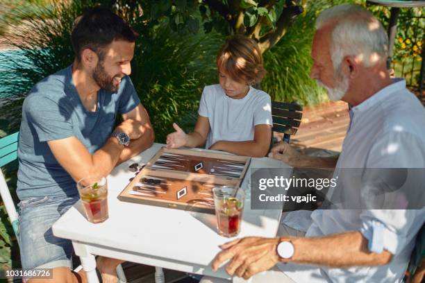 drie generaties mannetjes backgammon samenspelen - backgammon stockfoto's en -beelden