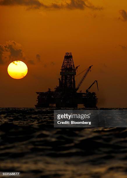 The Transocean Development Driller III leased by BP Plc is seen at sunset as it works to drill a backup relief well at the BP Plc Macondo well site...