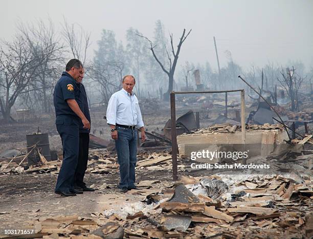 Russian Prime Minister Vladimir Putin and Emergency Minister Sergei Shoigu visit a village burnt by a forest fire on July 30, 2010 in Verkhnyaya...